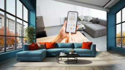 Controlling home heating temperature with a smart home, close-up on phone. Concept of a smart home and mobile application for managing smart devices at home Wall mural