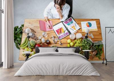 Dietitian writing diet plan, view from above on the table with different healthy products and drawings on the topic of healthy eating Wall mural