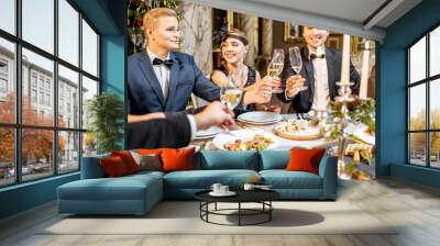 Elegantly dressed people having a festive dinner indoors Wall mural