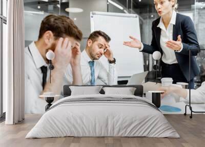 Female top manager or team leader quarreling at employees, dissatisfied with their work during a conference in the meeting room Wall mural