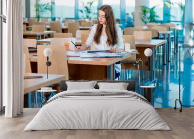 Girl studying in the University canteen with Fresh and cake Wall mural