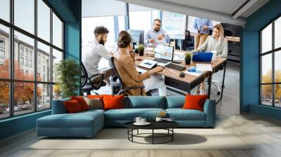 Group of diverse colleagues working in the modern office, having discussion or small conference on a working place with computers Wall mural