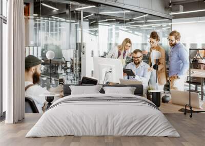 Group of diverse colleagues working on the computers in the modern office or coworking space, bearded hipster as a programmer writing code Wall mural