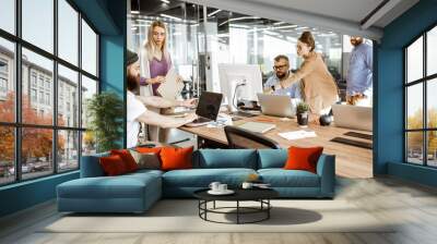 Group of diverse colleagues working on the computers in the modern office or coworking space, bearded hipster as a programmer writing code Wall mural