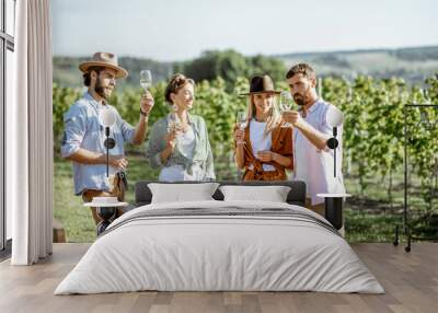 Group of young friends dressed casually having fun together, tasting wine on the vineyard on a sunny summer morning Wall mural