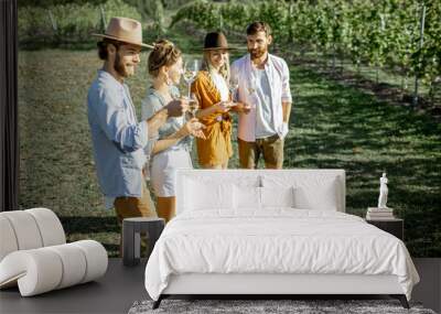 group of young friends dressed casually having fun together, tasting wine on the vineyard on a sunny Wall mural