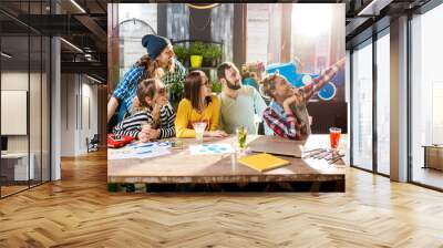 Group of young friends dressed casually making selfie photo sitting together in the modern cafe intreior Wall mural