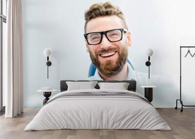 Handsome businessman with great smile sitting on the dental chair Wall mural