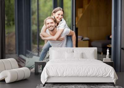 Happy lovely couple having fun playing together on the terrace outdoors of the modern house Wall mural