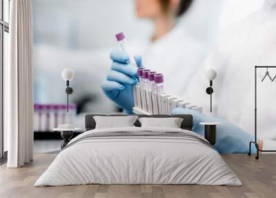 Laboratory assistant putting test tubes into the holder, Close-up view focused on the tubes Wall mural