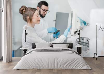 Laboratory assistants in unifrom working with professional medical analizer at the laboratory Wall mural