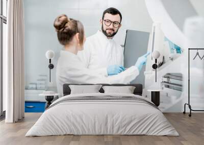 Laboratory assistants in unifrom working with professional medical analizer at the laboratory Wall mural