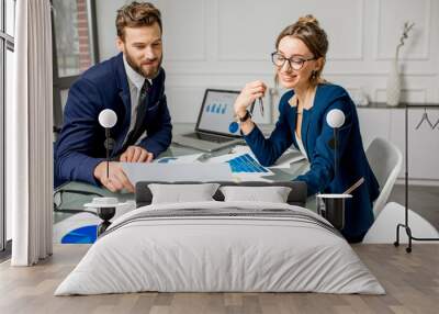 Marketer or analityc manager team dressed in suits working with paper charts and laptops at the white office interior Wall mural