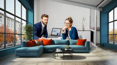 Marketer or analityc manager team dressed in suits working with paper charts and laptops at the white office interior Wall mural