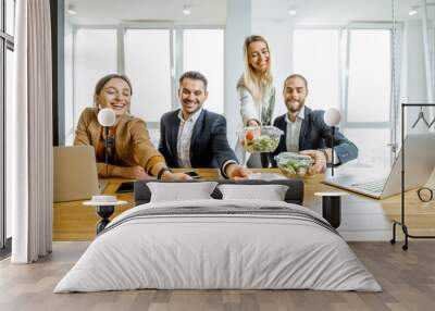 Portrait of a group of office workers taking business lunches in the office. Concept of healthy takeaway food on the work Wall mural