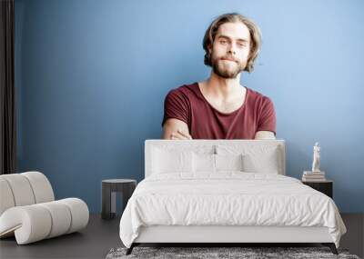 portrait of a young caucasian bearded man with long hair dressed in t-shirt on the colorful backgrou Wall mural