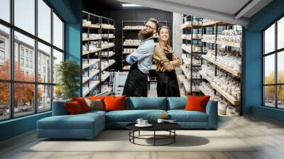 Portrait of young man and woman as a workers or business owners in the pottery shop Wall mural