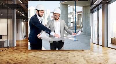 two business men or engeneers working with house drawings on the structure during the construction p Wall mural