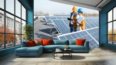 Two engineers or architects examining the construction of a solar power plant, walking with digital tablet on a rooftop Wall mural