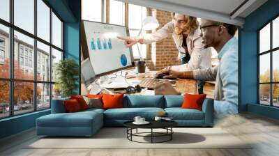 Two male coworkers working with analitycs in the beautiful office with brick wall on the background Wall mural