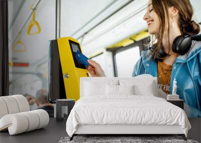 Woman paying conctactless with bank card for the public transport in the tram Wall mural