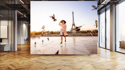 Woman running on the famous square dispersing pigeons with great view on the Eiffel tower early in the morning in Paris Wall mural