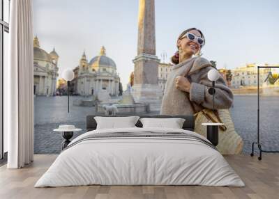 Woman walks on Piazza del Popolo in Rome city on a morning time. Female person with bag and colorful shawl in hair. Concept of italian lifestyle and travel Wall mural