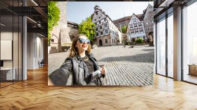 Young and happy woman tourist making selfie phooto traveling in Nurnberg, Germany Wall mural