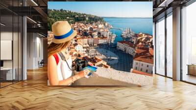 Young female traveler with red backpack and hat enjoying the view from George's tower on Piran old town. Traveling in Slovenia Wall mural