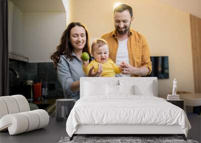 Young happy caucasian family with a little boy on the kitchen at home Wall mural