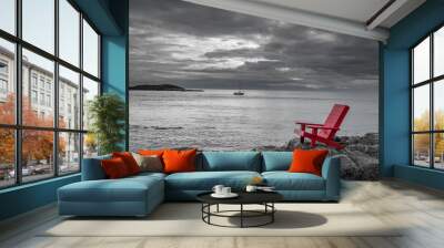 Red chair contrasting with black and white ocean background. Wall mural