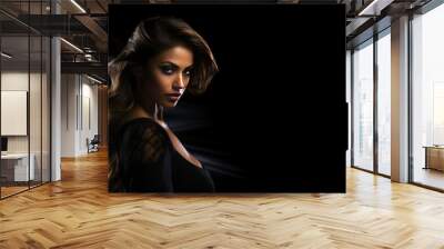 Sexy strict woman with black dress, tan skin, makeup and a fashionable hairstyle poses in studio on black background, with copyspace, blank space for text. Black friday shopping design concept Wall mural