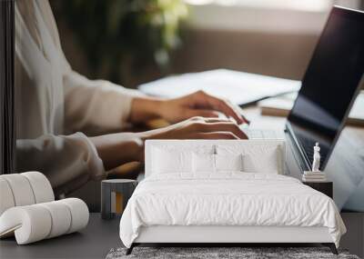 A writer deeply engrossed in typing a novel on a laptop, her fingers moving swiftly Wall mural