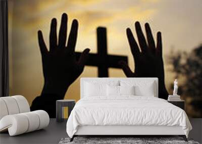 Hands raised in worship in front of a cross at sunset Wall mural