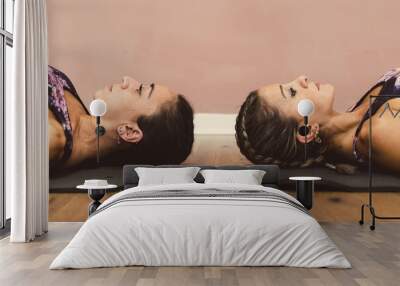 Portrait of two fitness women lying down at pole dance academy Wall mural