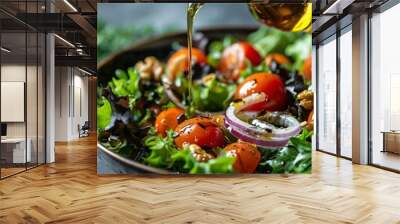 Hand pouring golden olive oil over a vibrant bowl of mixed salad with tomatoes and onions in a closeup shot Wall mural