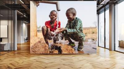 African young children drinking fresh clean water from a tap. Wall mural