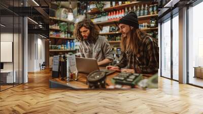 Smiling florist holding card reader machine at counter with customer paying with credit card. Young african american florist shop assistant holding payment machine while buyer purchase a bunch flower. Wall mural