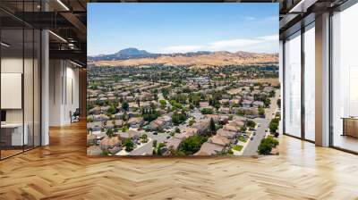 Aerial images over a community in Antioch, California with houses, cars, streets and trees. With a blue sky and room for text Wall mural