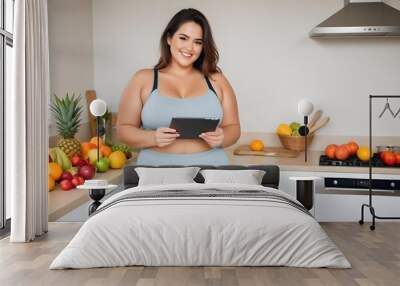 Overweight woman started to exercise in kitchen full of fruit and ipad in her hands Wall mural