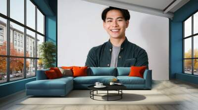 portrait smile and asian man with arms crossed casual fashion and confident guy against a white studio background face male person and japanese model with happiness aesthetic and stylish outfit Wall mural