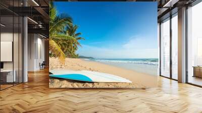 surfboard on sandy tropical beach with palm trees under clear blue sky water sports during summer vacation Wall mural