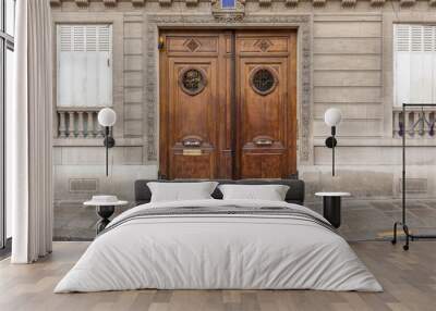 Two beautiful and decorative wooden doors on side of classic Paris building with wet sidewalk Wall mural