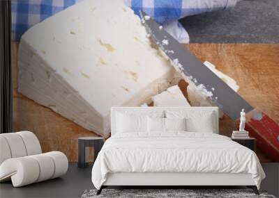 Morceau de feta sur une planche à découper avec un couteau en gros plan Wall mural