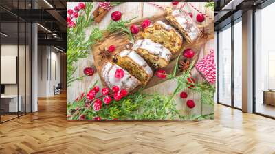 Christmas stollen with icing sugar, marzipan and raisins. Traditional Dresden christ pastry. On table background with fir tree branches and Christmas decoratioon top view copy space Wall mural