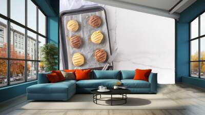 Cooking making mexican traditional conchas pastry, cookie or bread buns. Homemade preparation of conchas dessert pastry, on baking sheet with man hands in pic, top view copy space Wall mural