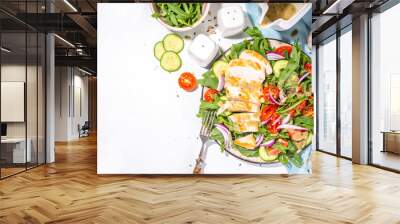 Grilled chicken fillet with vegetable salad. White meat, chicken or turkey breast, with fresh vegetables and greens salad, tomato, arugula, cucumber, onion, green olive oil sauce on white background Wall mural