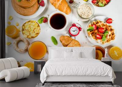 Healthy breakfast eating concept, various morning food - pancakes, waffles, croissant oatmeal sandwich and granola with yogurt, fruit, berries, coffee, tea, orange juice, white background Wall mural