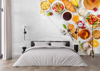 Healthy breakfast eating concept, various morning food - pancakes, waffles, croissant oatmeal sandwich and granola with yogurt, fruit, berries, coffee, tea, orange juice, white background Wall mural