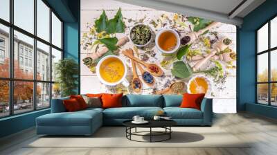 Healthy drinks, harvest herbs and flowers concept. Fresh and dried organic herbal, set of different floral tea variations, with brewed hot tea cups on white wood table copy space Wall mural